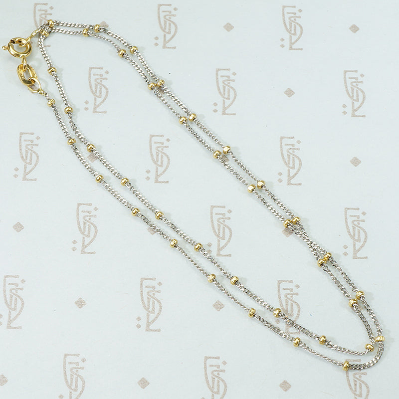 18k white gold cuban link chain with a shiny finish and 18k yellow gold bead staions