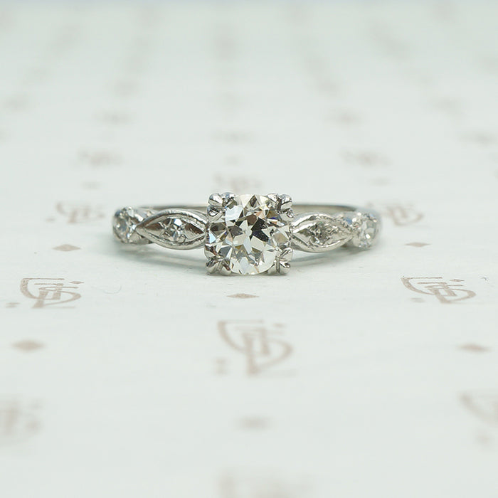 fancy triple split prongs hold an old euro diamond in a platinum setting all original circa 1940 engagement ring with interesting shaped diamond set side details.