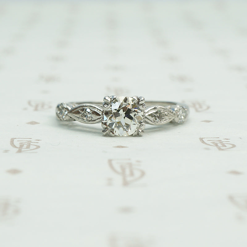 fancy triple split prongs hold an old euro diamond in a platinum setting all original circa 1940 engagement ring with interesting shaped diamond set side details.