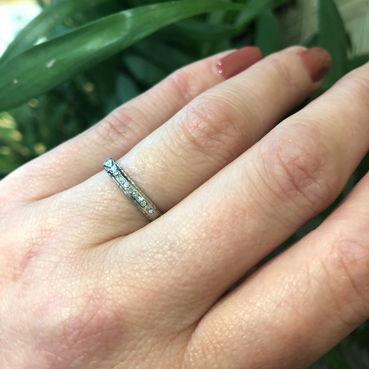 channel set diamond white gold band with arrow design on hand