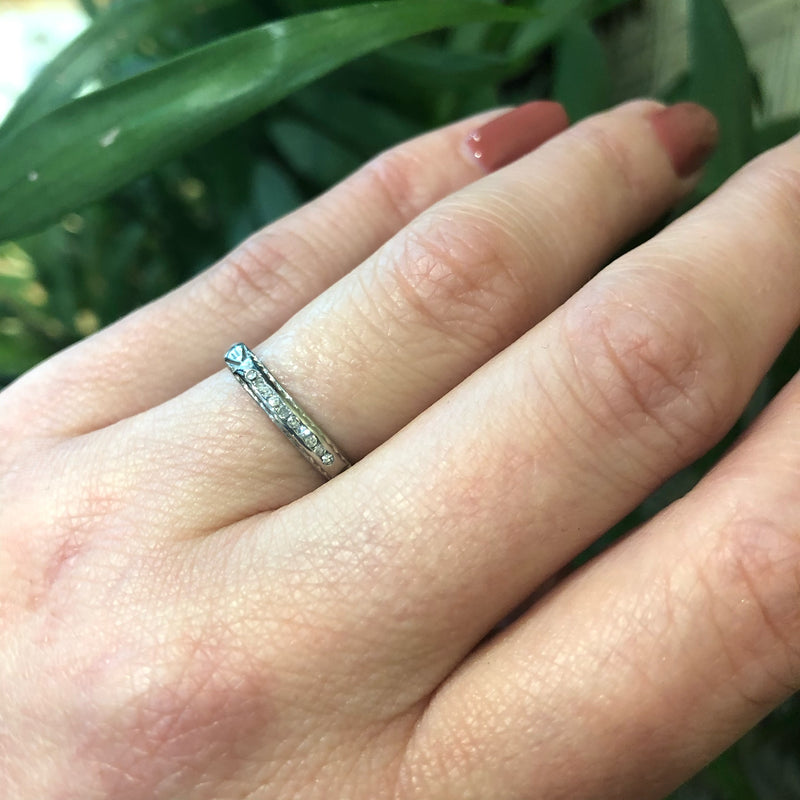 channel set diamond white gold band with arrow design on hand
