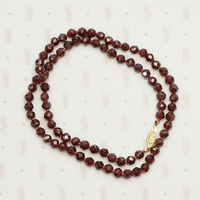 Pretty Strand of Hand Knotted Faceted Garnet Beads. Coiled view.