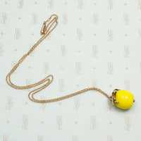 Glass yellow apple topped with 14k gold leaves on a 9ct yellow gold chain circa 1910