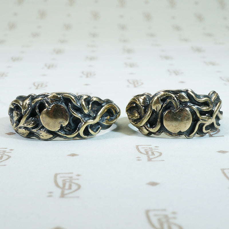 gold vines and apples adorn the surface of this pair of 19th century silver wedding bands