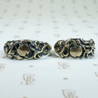 gold vines and apples adorn the surface of this pair of 19th century silver wedding bands