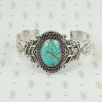 american silver cuff with arrow pattern and big turquoise