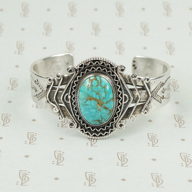 american silver cuff with arrow pattern and big turquoise
