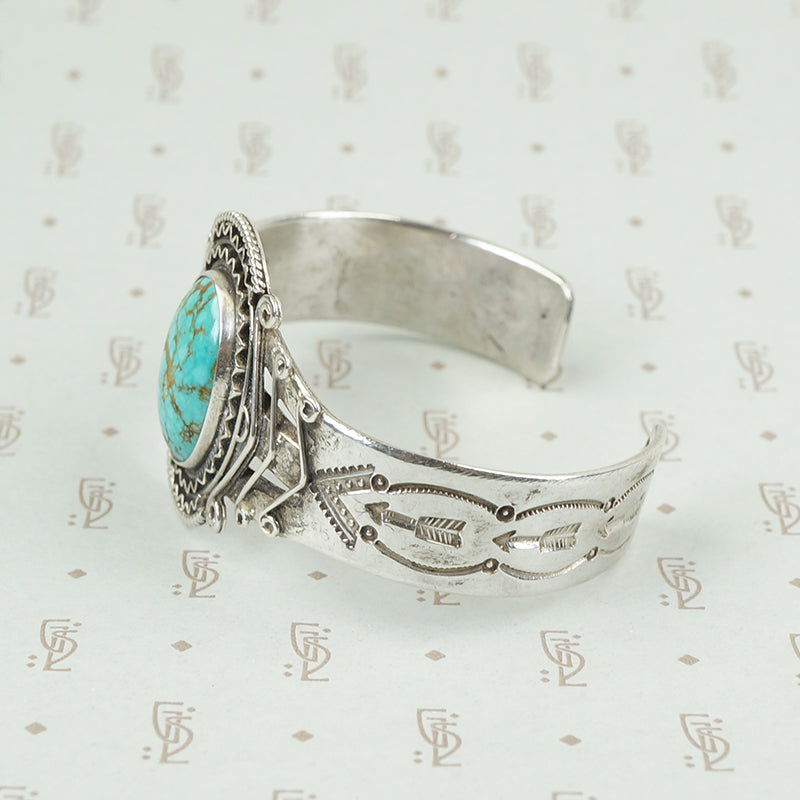 american silver cuff with arrow pattern and big turquoise