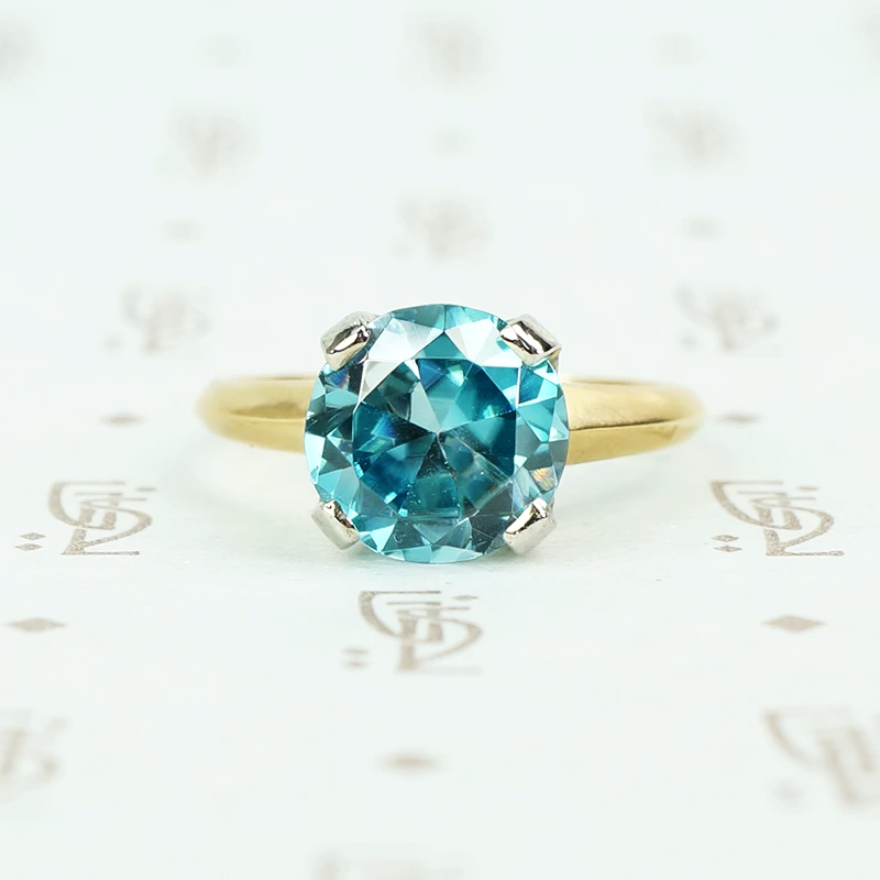Natural blue zircon solitaire in palladium and 14k yellow gold