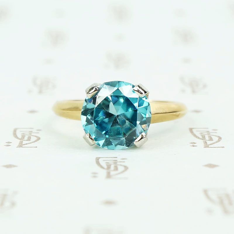Natural blue zircon solitaire in palladium and 14k yellow gold