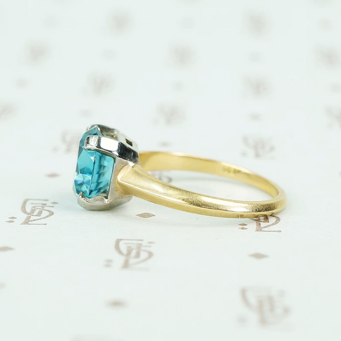 Natural blue zircon solitaire in palladium and 14k yellow gold side view