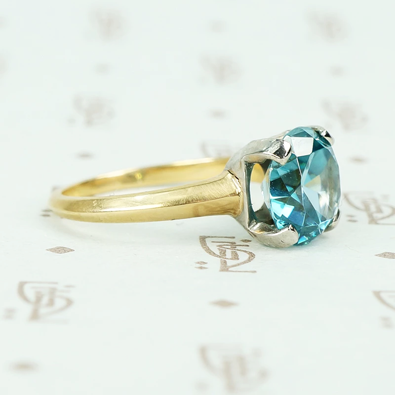 Natural blue zircon solitaire in palladium and 14k yellow gold side view