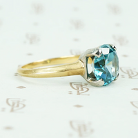 Natural blue zircon solitaire in palladium and 14k yellow gold side view