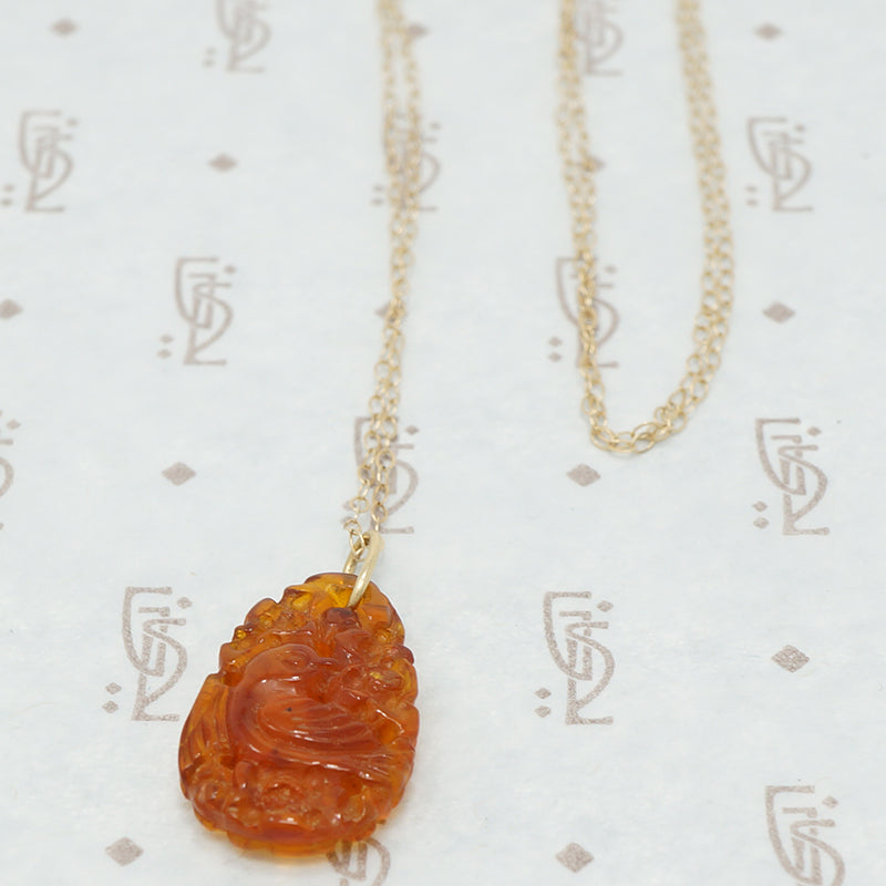 carved amber pendant with birds