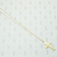 hand engraved cross flowers on the fron and a personal sentiment on the back suspended from a 14k recycled 14k gold chain
