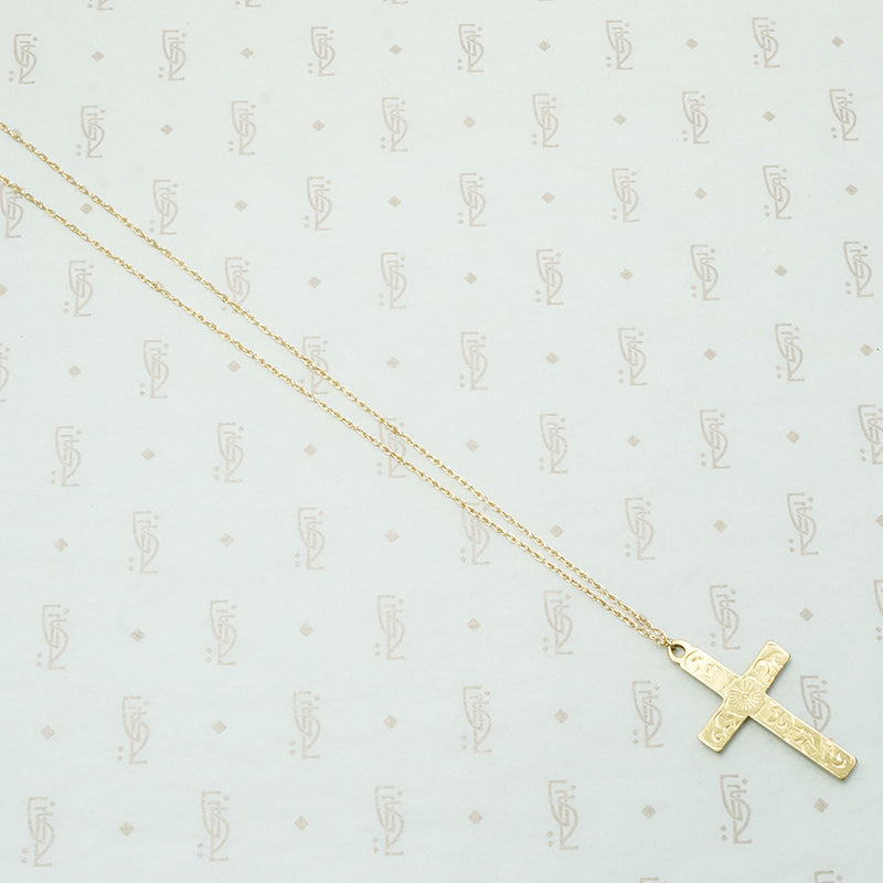 hand engraved cross flowers on the fron and a personal sentiment on the back suspended from a 14k recycled 14k gold chain