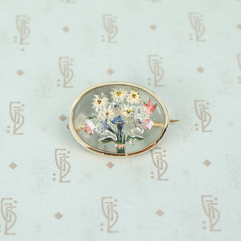 boquet of flowers in reverse carved crystal in a 14k yellow gold frame brooch