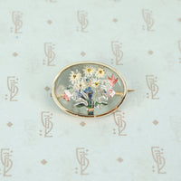 boquet of flowers in reverse carved crystal in a 14k yellow gold frame brooch