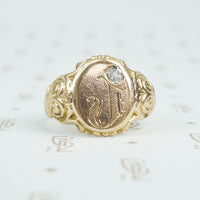 Gold signet ring with engraved j topped with a mine cut diamond