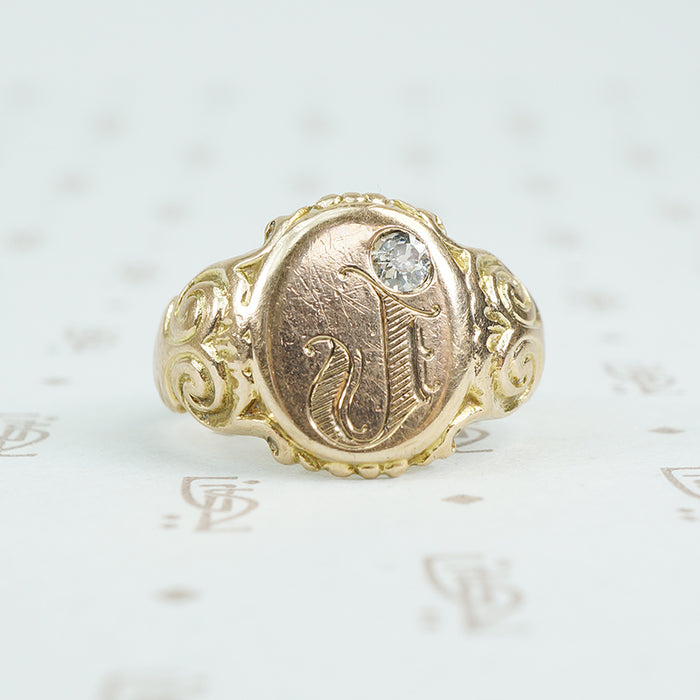 Gold signet ring with engraved j topped with a mine cut diamond