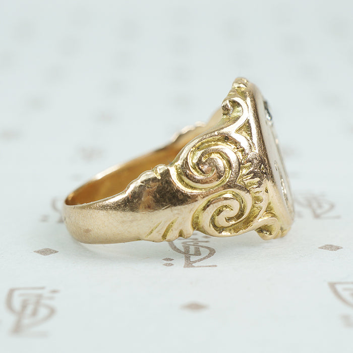 Gold signet ring with engraved j topped with a mine cut diamond side detail of scrolls