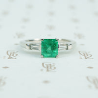 Square green emerald in platinum engaement ring with diamond baguette sides