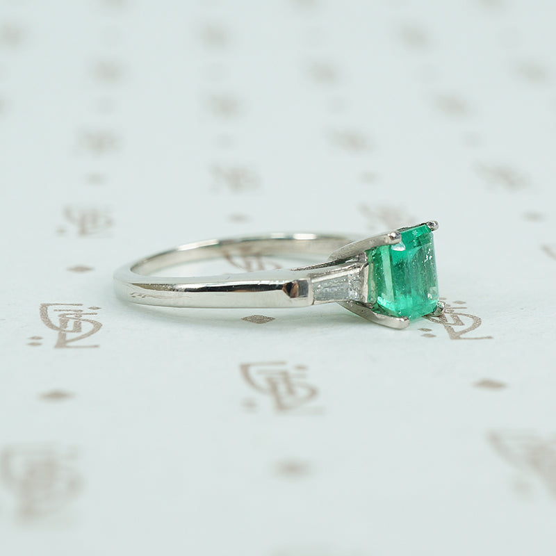 Square green emerald in platinum engaement ring with diamond baguette sides
