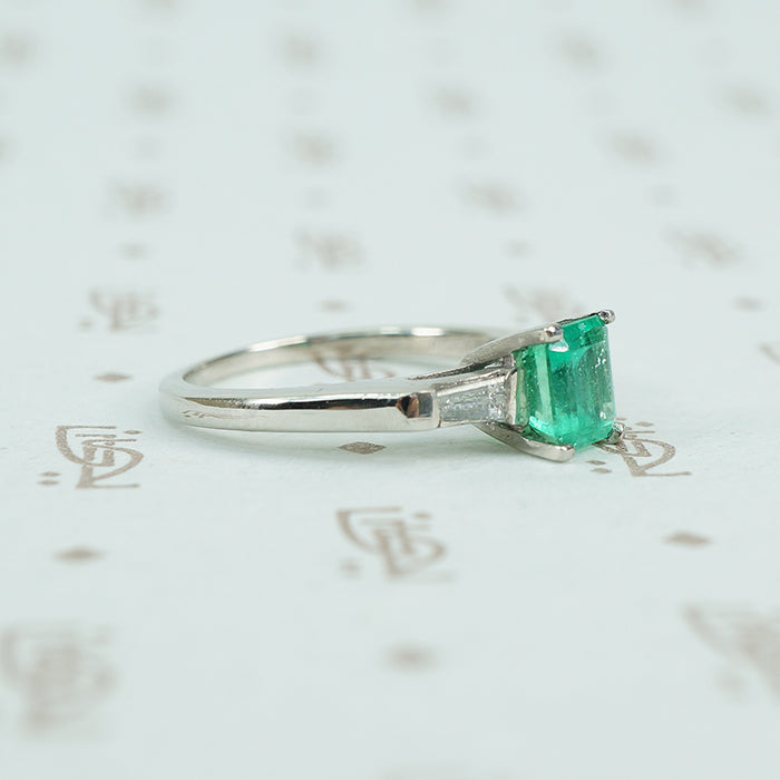 Square green emerald in platinum engaement ring with diamond baguette sides
