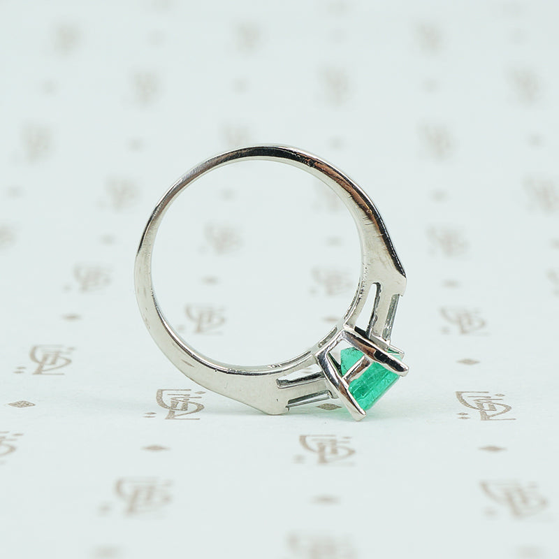 Square green emerald in platinum engaement ring with diamond baguette sides