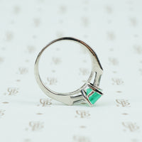 Square green emerald in platinum engaement ring with diamond baguette sides