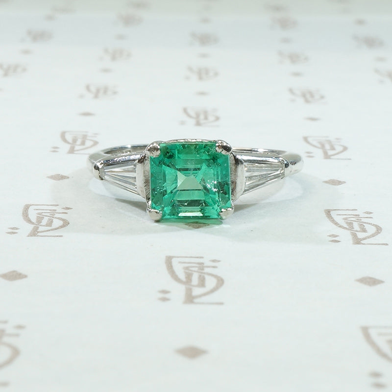 beautiful grass green step cut emerald flanked by tapered baguette diamonds in platinum vintage 1940's engagement ring
