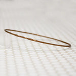 The Endless Twist Oval Bangle in Bronze from Allie B.