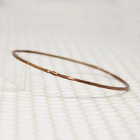 The Endless Twist Round Bangle in Bronze from Allie B.