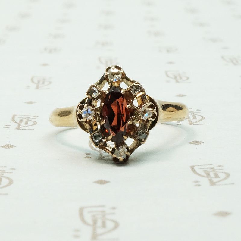 A beautiful rust red marquis shaped garnet surrounded by rose cut diamonds antique ring
