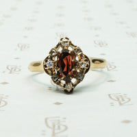 A beautiful rust red marquis shaped garnet surrounded by rose cut diamonds antique ring