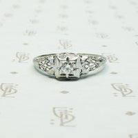 lacy filigree white gold diamond ring with a square set diamond
