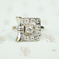 14k white gold square ring of forget me not flowers with .10 point diamond at the center