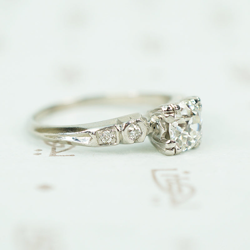 side view of platinum and oec diamond engagement ring with inverted fish tail detail