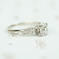 side view of platinum and oec diamond engagement ring with inverted fish tail detail