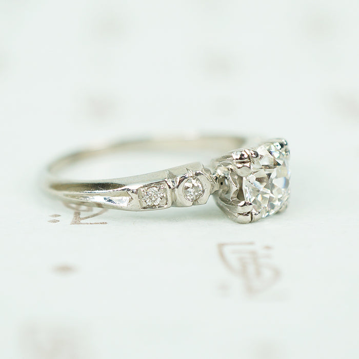 side view of platinum and oec diamond engagement ring with inverted fish tail detail