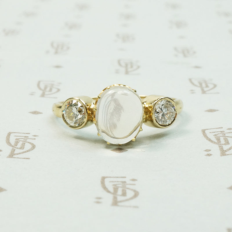 vintage moonstone in its original setting flanked by bezel set old diamonds in 14k recycled yellow gold ring