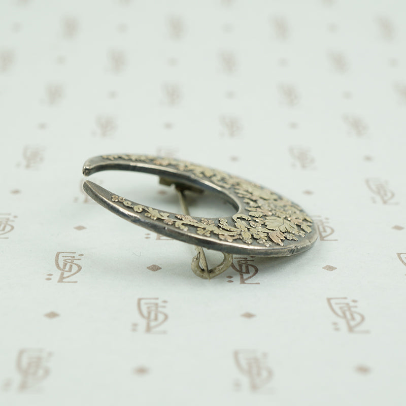 side view of moon and flowers brooch