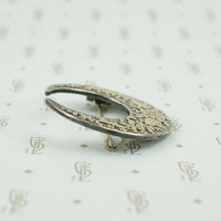 side view of moon and flowers brooch