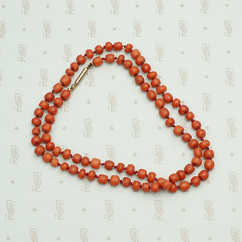 Deep Red Antique Coral Beads on Silk, coiled.