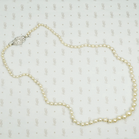 Lovelu long graduated strand of matinee length cultured graduated pearls with an elaborate diamond and platinum clasp
