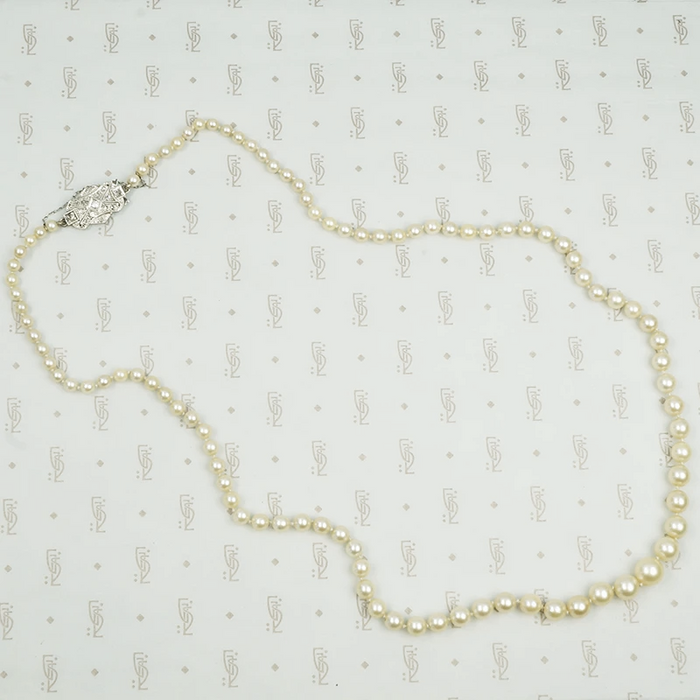 Lovelu long graduated strand of matinee length cultured graduated pearls with an elaborate diamond and platinum clasp