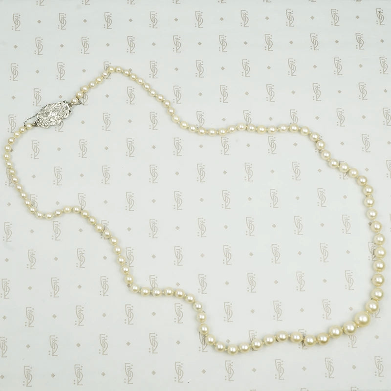 Lovelu long graduated strand of matinee length cultured graduated pearls with an elaborate diamond and platinum clasp