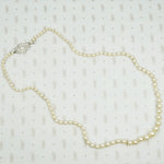 Lovelu long graduated strand of matinee length cultured graduated pearls with an elaborate diamond and platinum clasp