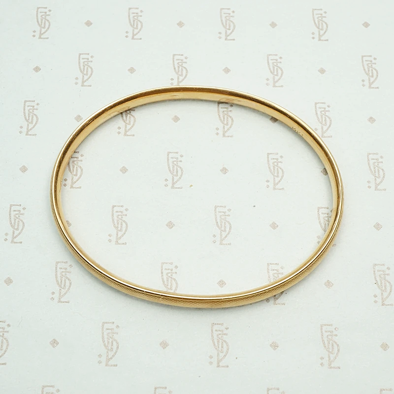 Engraved Gold Vintage Bangle Signed Krementz. Top view.