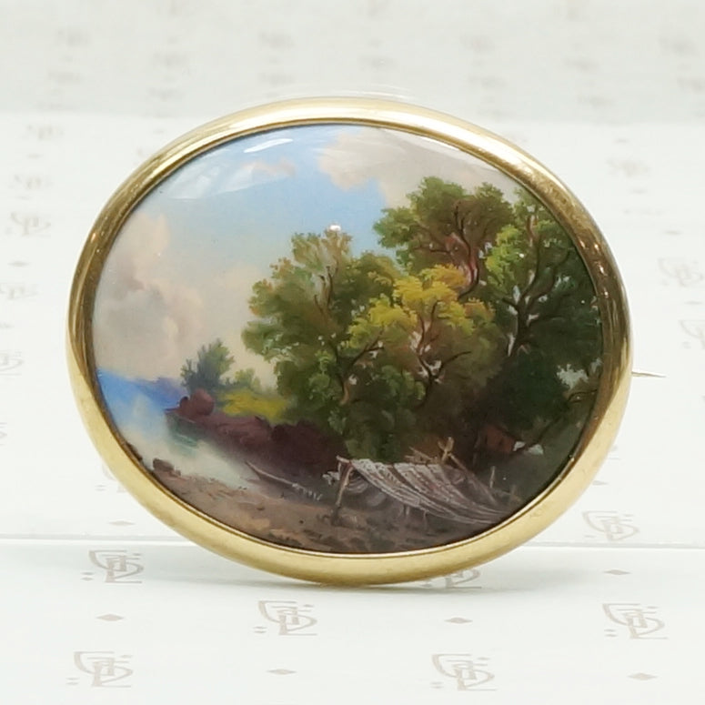 hand painted enamel scene of life on a river set in a 14k yellow gold frame can be worn as a brooch or pendant
